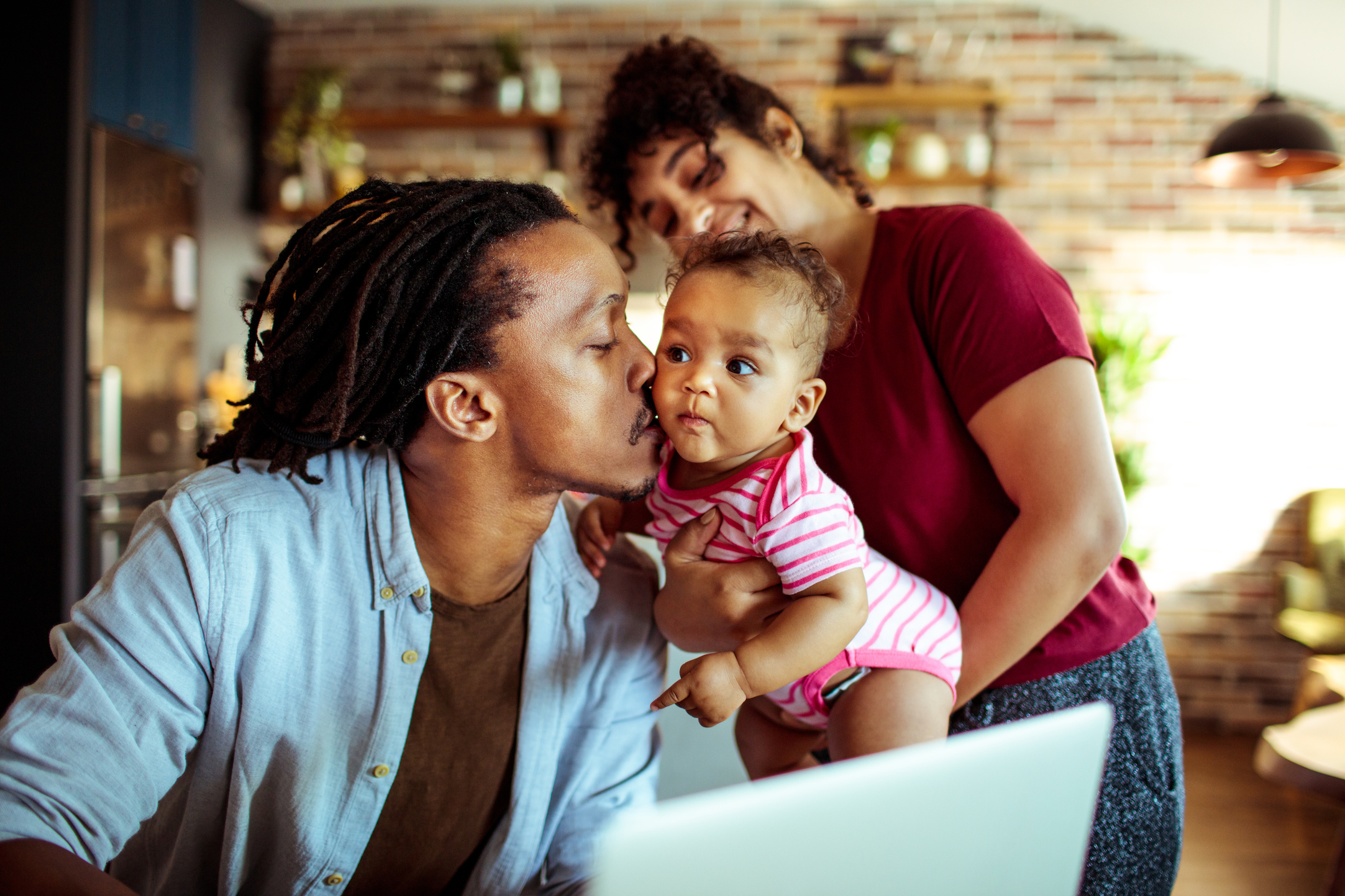 Close up of a young family in their living room using a laptop