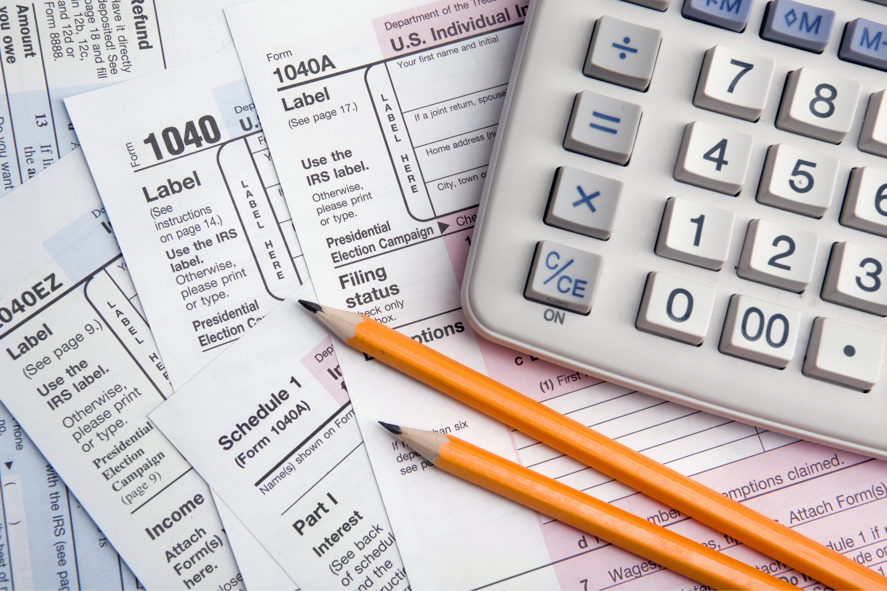 Pencils and a calculator on top of a stack of forms.